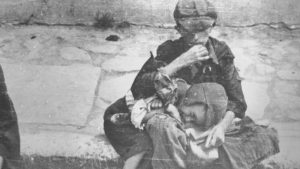 Crianças carentes sentam-se na calçada do gueto de Varsóvia. Crédito: United States Holocaust Memorial Museum