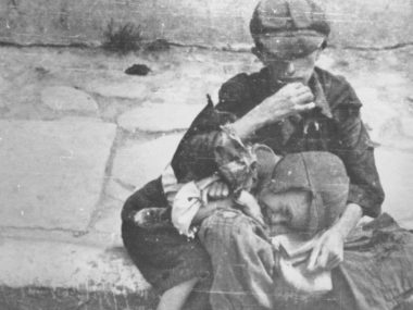 Crianças carentes sentam-se na calçada do gueto de Varsóvia. Crédito: United States Holocaust Memorial Museum